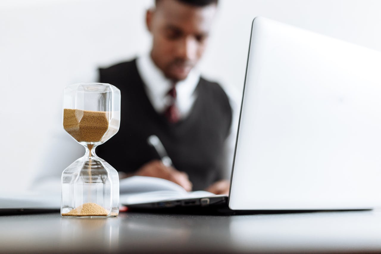 Services-02 Businessman at desk with hourglass indicating time management and daily work routine.